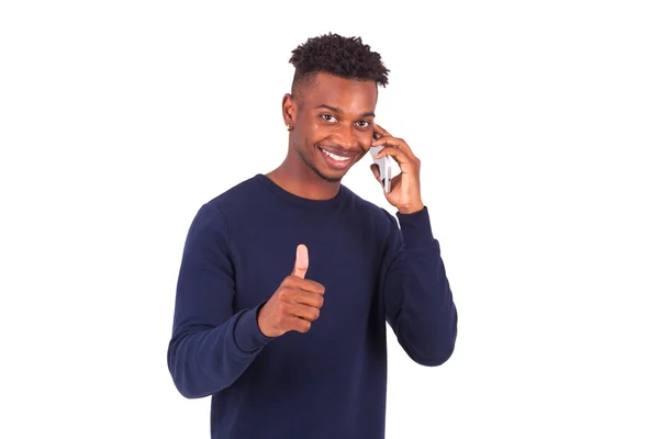 Joven afroamericano sosteniendo un teléfono inteligente pulgares hacia arriba — Foto de Stock