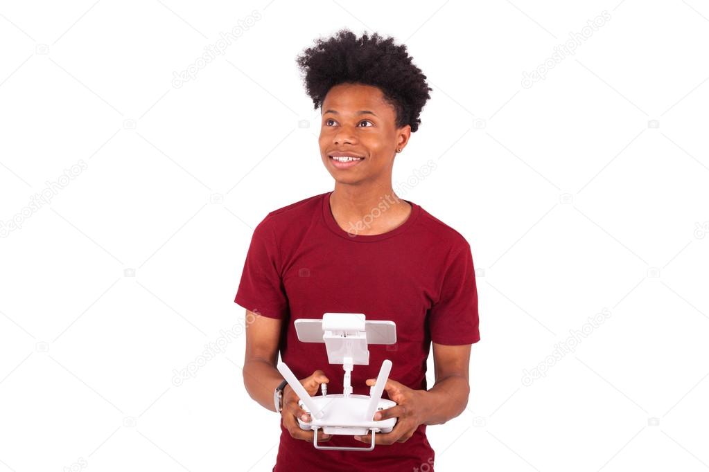 African American young man holding a drone remote control over w