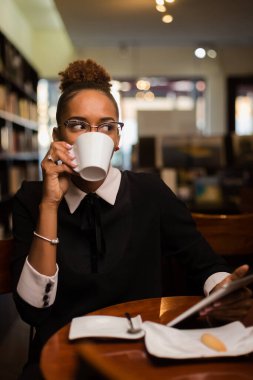 Siyah Afrikalı Amerikalı genç adam kahve içiyor.