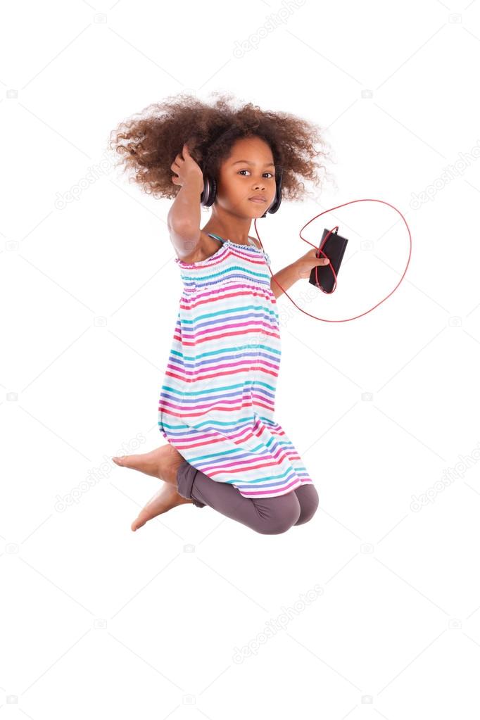 Little african american girl jumping and listening to music - Bl