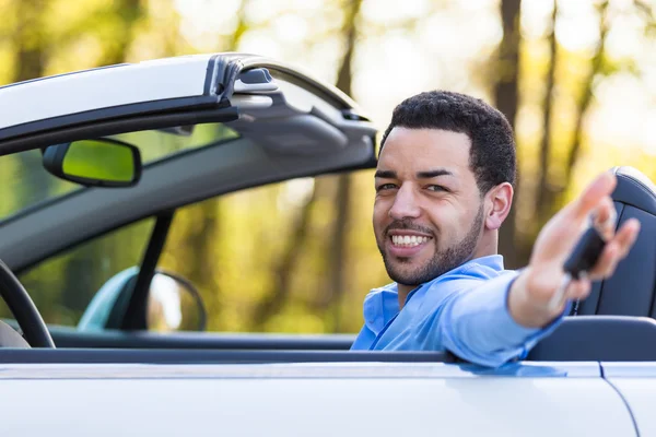 Młody czarny Łacińskiej kierowca posiadający kluczyki do samochodu jazdy jego n — Zdjęcie stockowe