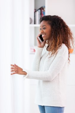 Afrikalı Amerikalı kadın telefonda konuşuyor.