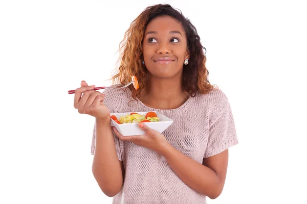 Femme afro-américaine mangeant de la salade, isolée sur fond blanc — Photo