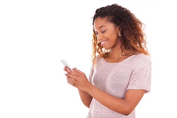 Afrikanisch-amerikanische junge Frau sendet eine SMS auf ihrem Smart — Stockfoto