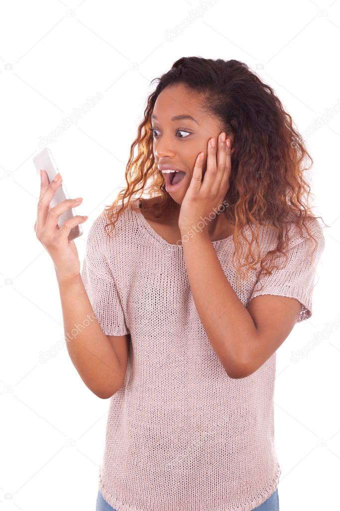 Ecstatic young African American woman making a phone call on her
