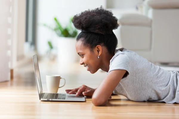 Afrikai-amerikai nő használ egy laptop a nappaliban - fekete — Stock Fotó