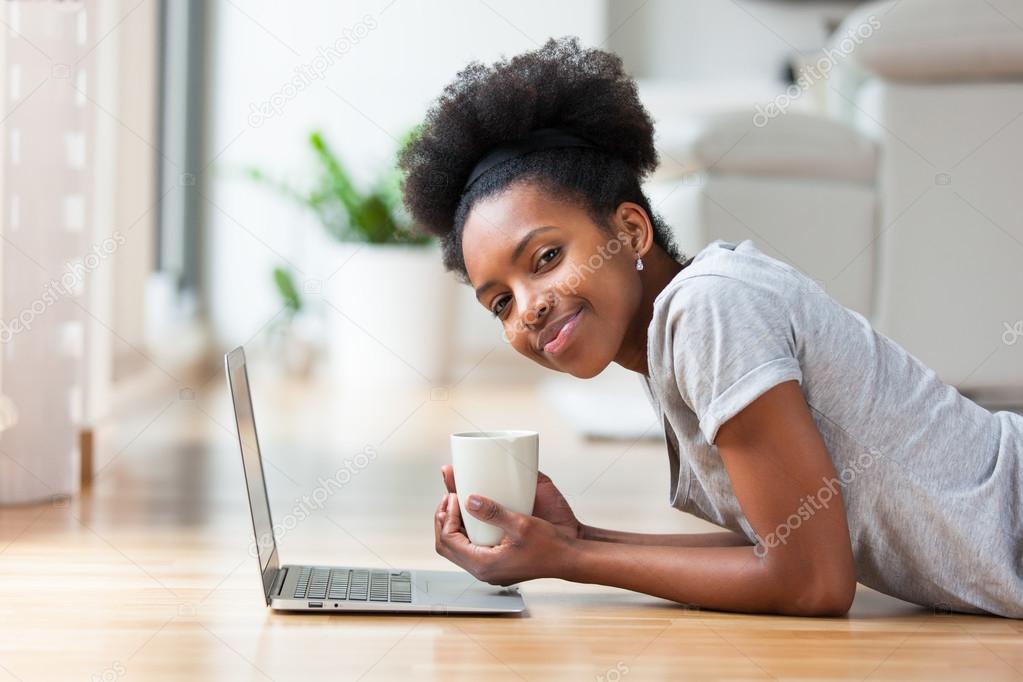 African American woman using a laptop in her living room - Black