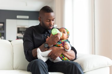 Kız onu bebek için süt veren genç Afro-Amerikan baba bir