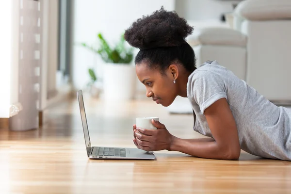 Mujer afroamericana usando un portátil en su sala de estar - Negro —  Fotos de Stock