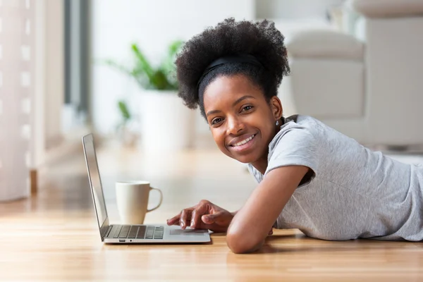 African American vrouw met behulp van een laptop in haar woonkamer - zwart — Stockfoto