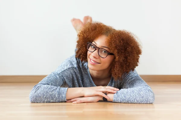 African American teenage girl lying down on floor — Stock Photo, Image