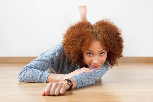 African American teenage girl lying down on floor — Stock Photo, Image