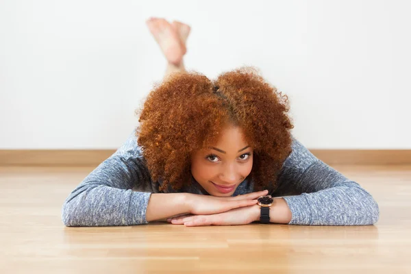 African American teenage girl lying down on floor — Stock Photo, Image