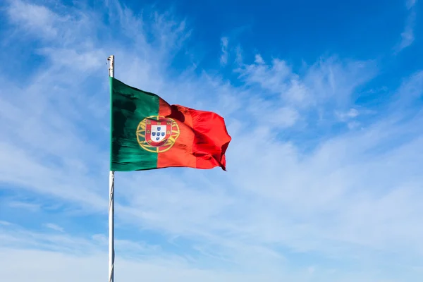 Portugal vlag zwaaien op de wind over een helder blauwe hemel — Stockfoto