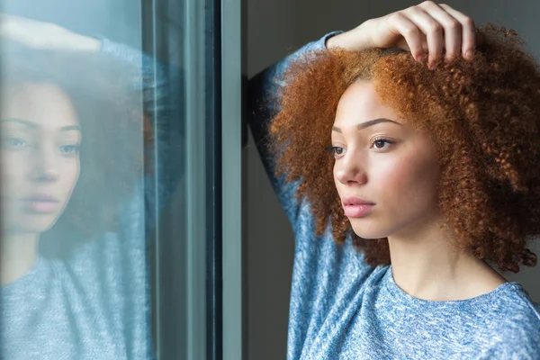 Black African American tonårig flicka tittar genom ett fönster — Stockfoto