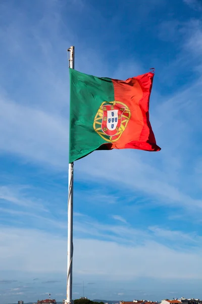 Portugal vlag zwaaien op de wind over een helder blauwe hemel — Stockfoto