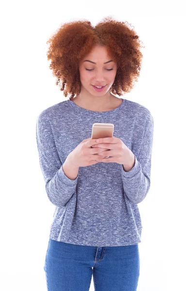 Jovem mulher enviando uma mensagem de texto em seu telefone — Fotografia de Stock