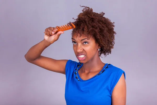 Jonge African American vrouw kammen haar afro kroeshaar - zwart — Stockfoto