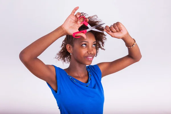 Young African American woman cutting her frizzy afro hair with s — Stock Photo, Image