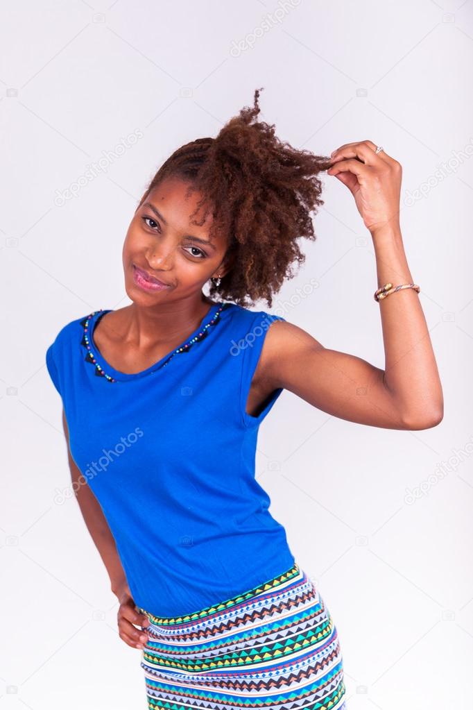 Young African American woman holding her frizzy afro hair - Blac