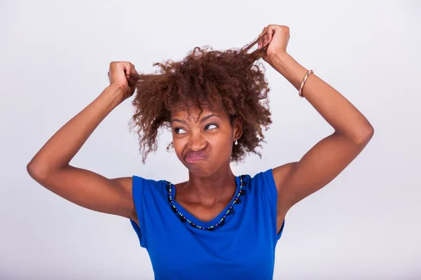 Joven mujer afroamericana sosteniendo su pelo afro muy rizado - Blac — Foto de Stock