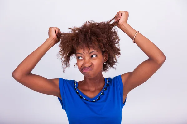 Young African American woman holding her frizzy afro hair - Blac — Stock Photo, Image