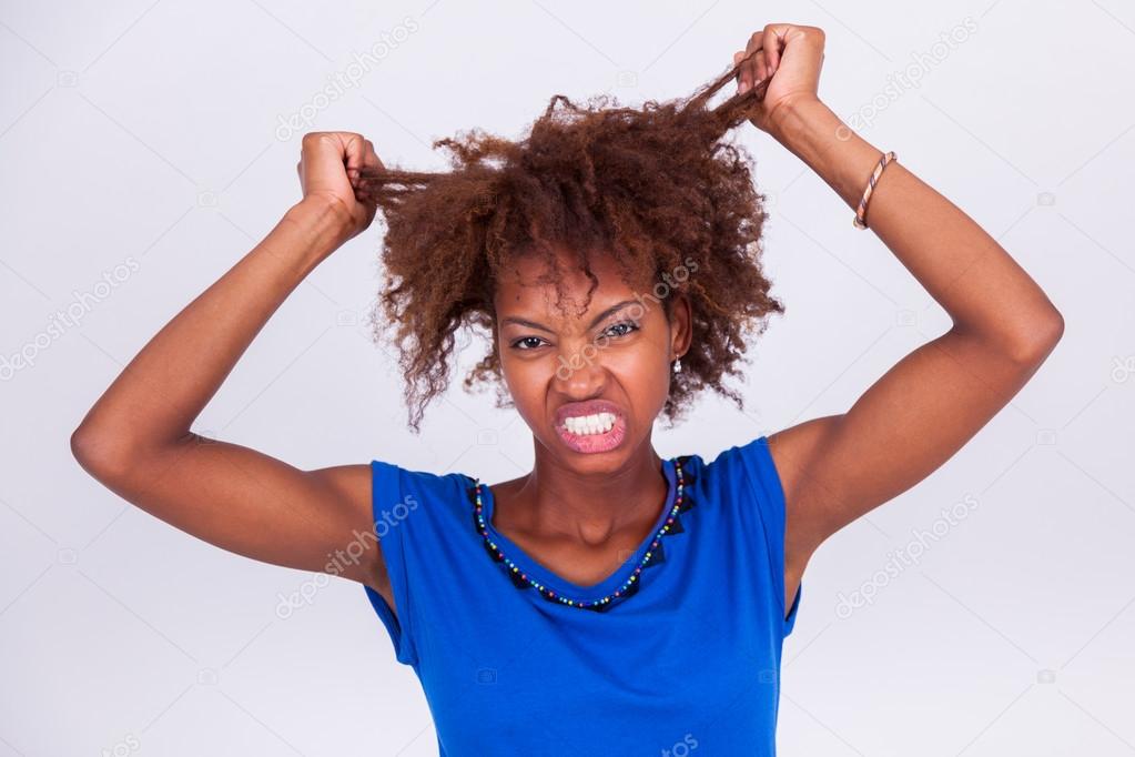 Young African American woman holding her frizzy afro hair - Blac