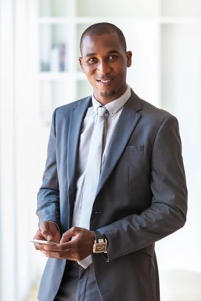 Portrét mladé afroamerické obchodní člověka pomocí mobilní — Stock fotografie