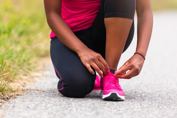 Mujer afroamericana corredora apretando el encaje del zapato - Fitness, pe — Foto de Stock