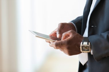 Afrika kökenli Amerikalı iş adamı dokunsal tablet üzerinde beyaz kullanma 