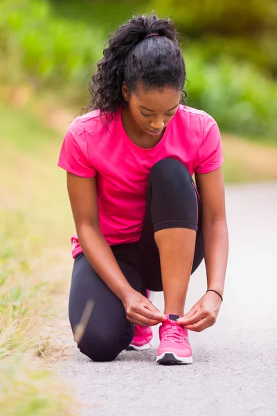 Mujer afroamericana corredora apretando el encaje del zapato - Fitness, pe — Foto de Stock