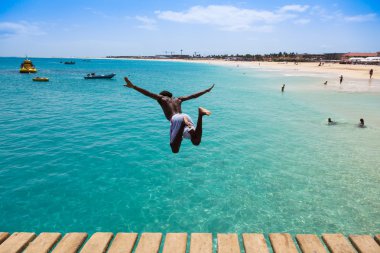Teenage Cape verdean çocuk Sant turkuaz su üzerinde atlama