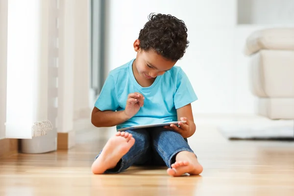 Afrikanischer kleiner Junge mit einem taktilen Tablet — Stockfoto