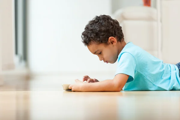 Niño afroamericano usando una tableta táctil — Foto de Stock