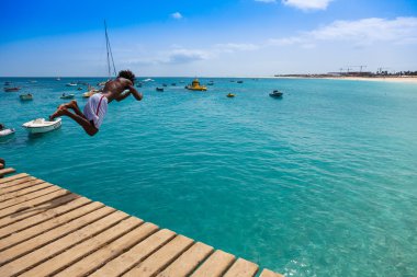 Teenage Cape verdean çocuk Sant turkuaz su üzerinde atlama