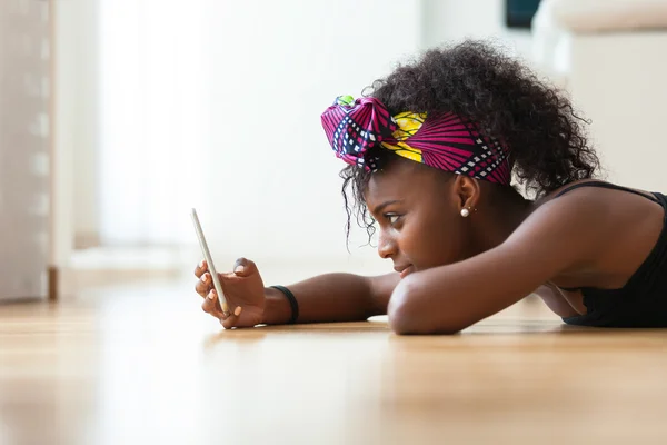 Africano mulher americana enviando uma mensagem de texto em um telefone celular — Fotografia de Stock