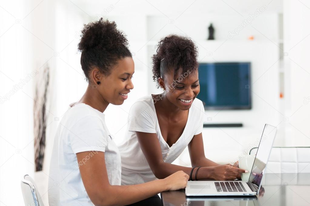 African American student girls using a laptop computer - black p