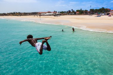 Teenage Cape verdean çocuk Sant turkuaz su üzerinde atlama