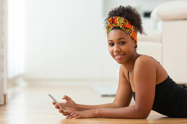 Mujer afroamericana enviando un mensaje de texto en un teléfono móvil —  Fotos de Stock