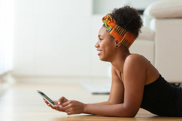 Mujer afroamericana enviando un mensaje de texto en un teléfono móvil —  Fotos de Stock
