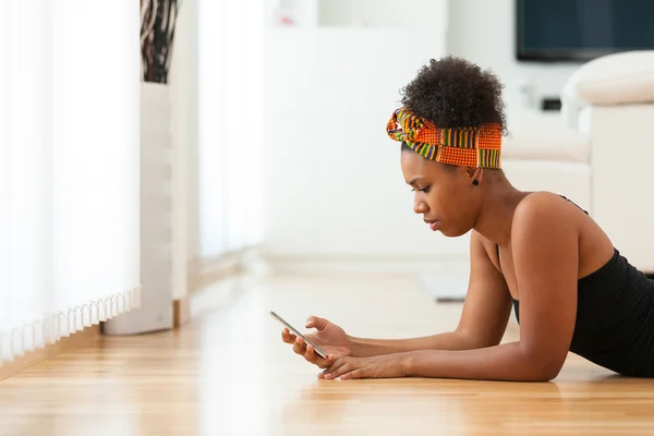 Mujer afroamericana enviando un mensaje de texto en un teléfono móvil —  Fotos de Stock