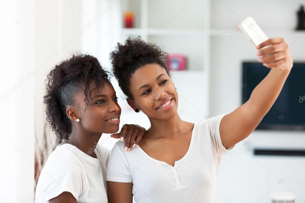 African American teenage girls taking a selfie picture with a sm