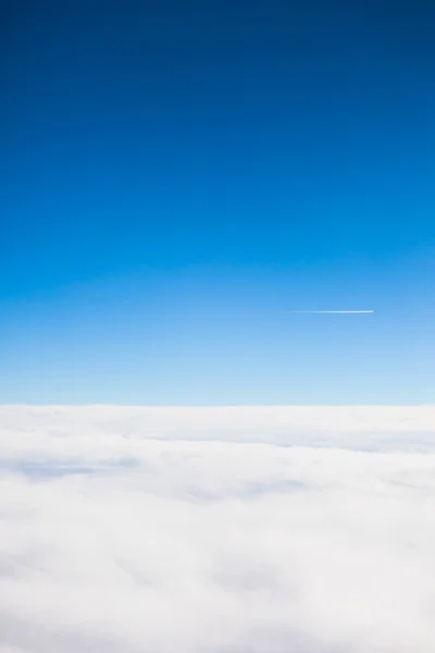 Volando por encima de las nubes vista desde un agujero de buey de avión —  Fotos de Stock