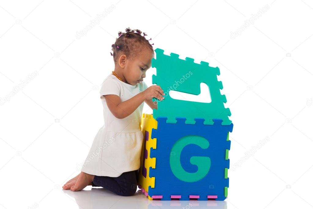 Little African American baby girl playing with construction game