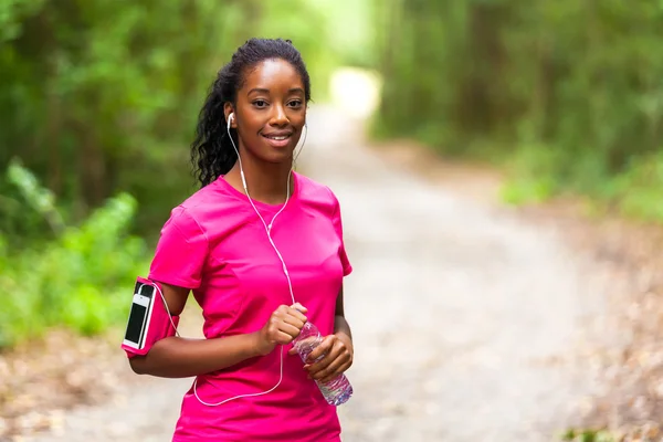 Donna afroamericana jogger in possesso di una bottiglia d'acqua - Fitness — Foto Stock