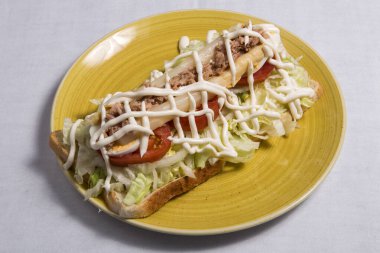 Beyaz arka planda yumurtalı ve kuşkonmaz soslu sandviç.