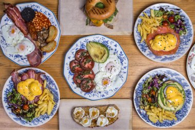 Farklı ev yapımı brunchlar, ahşap arka planda üst görünüm.