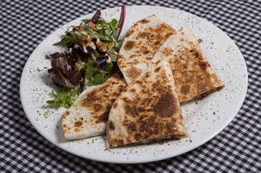 Beyaz tabakta salatalı Meksika quesadilla 'sı