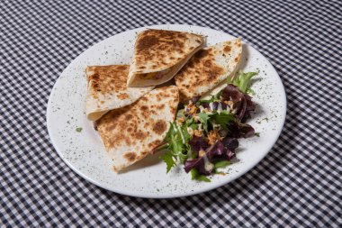 Beyaz tabakta salatalı Meksika quesadilla 'sı