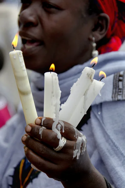 The woman prays with the burning candles in hands. — Stock Photo, Image